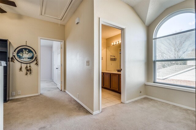 corridor with a wealth of natural light, light carpet, and lofted ceiling