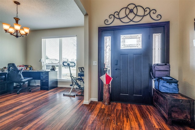 entrance foyer with a chandelier, a textured ceiling, and dark hardwood / wood-style flooring