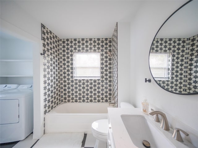 bathroom with a wealth of natural light, toilet, vanity, and independent washer and dryer