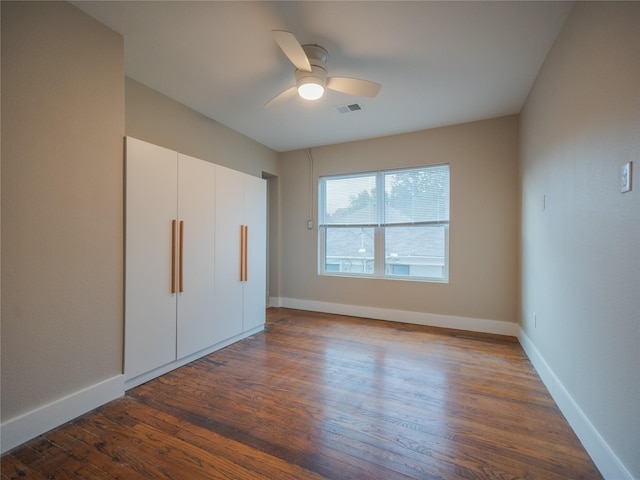 unfurnished bedroom featuring ceiling fan and dark wood-type flooring