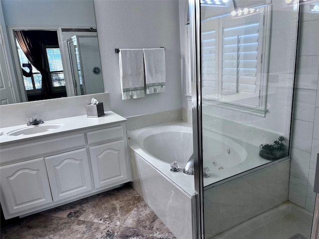 bathroom with vanity and shower with separate bathtub