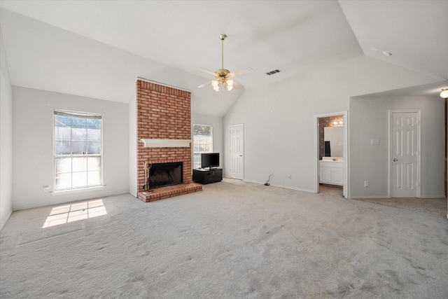 unfurnished living room featuring high vaulted ceiling, a brick fireplace, light colored carpet, and ceiling fan