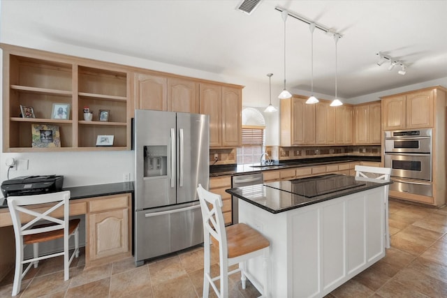 kitchen with sink, hanging light fixtures, a breakfast bar area, light brown cabinetry, and appliances with stainless steel finishes