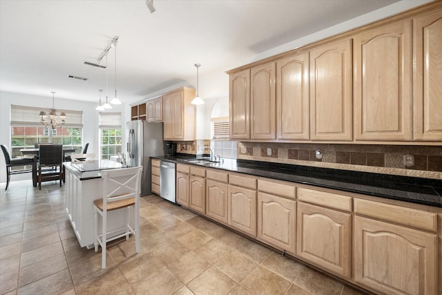 kitchen featuring decorative light fixtures, a kitchen island, decorative backsplash, and stainless steel appliances