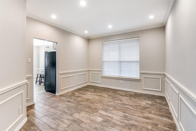 unfurnished room featuring hardwood / wood-style floors and crown molding