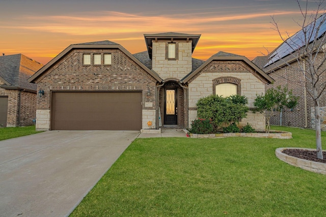 french country home with a garage and a lawn