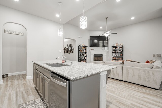 kitchen with dishwasher, a center island with sink, sink, ceiling fan, and gray cabinets