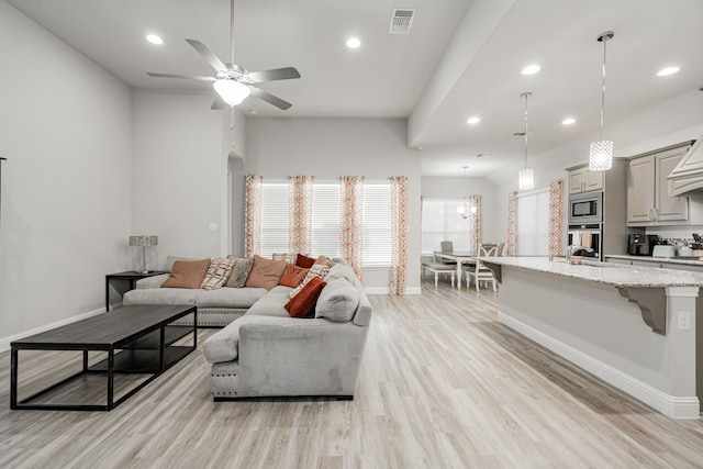 living room featuring light wood-type flooring, ceiling fan, and sink