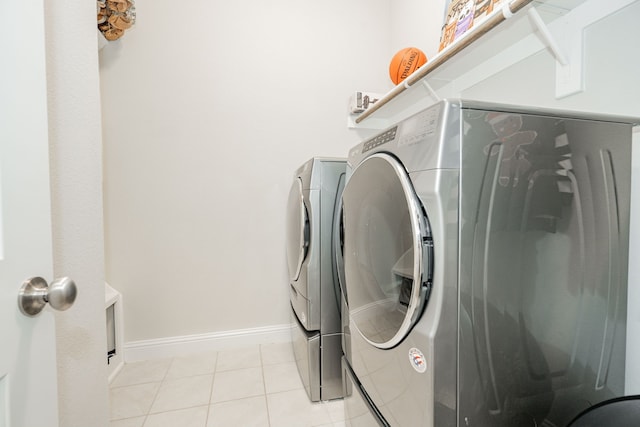 laundry area featuring light tile patterned floors and separate washer and dryer