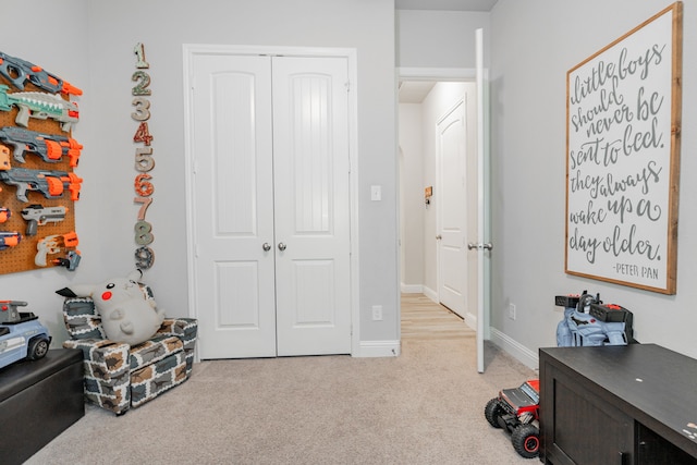 interior space featuring light colored carpet and a closet