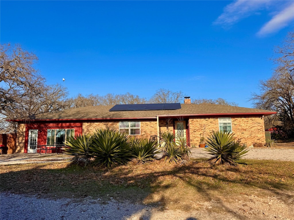 rear view of property featuring solar panels