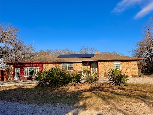 rear view of property featuring solar panels