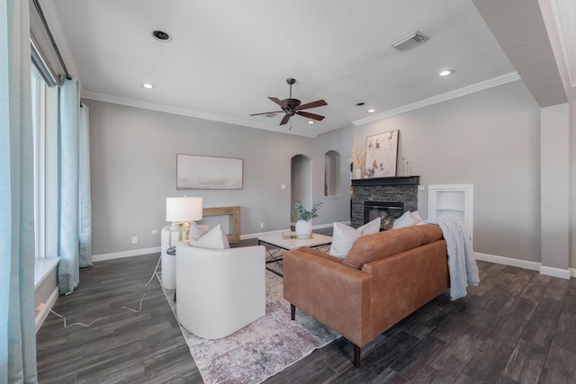 living room featuring a fireplace, ceiling fan, and crown molding