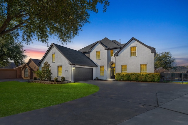 view of front of home with a yard and a garage