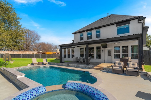 back of property with a pool with hot tub, a patio, and a lawn