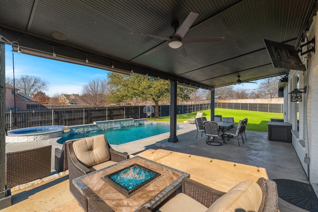 view of swimming pool featuring a patio, a lawn, ceiling fan, pool water feature, and an in ground hot tub