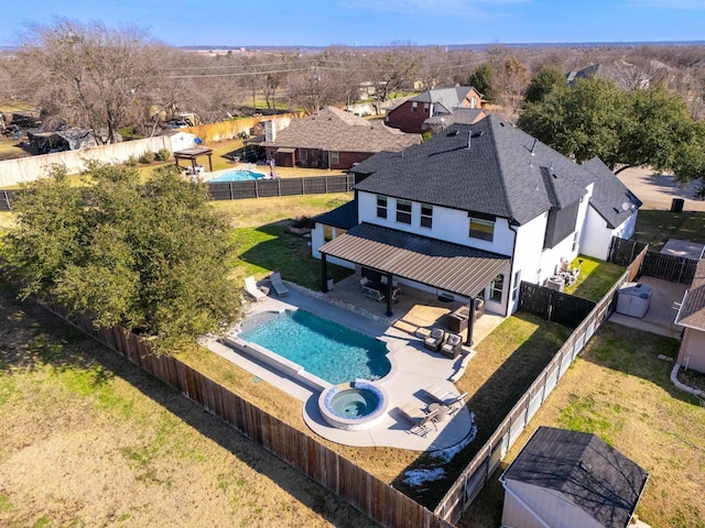 view of pool with a lawn, an in ground hot tub, a storage shed, and a patio area