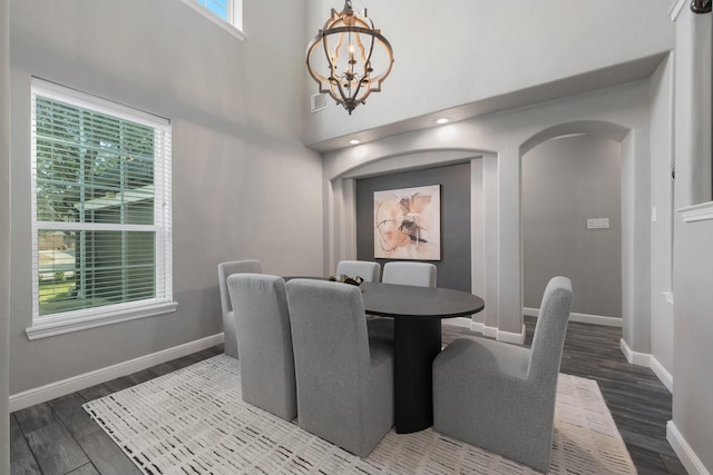 dining space with an inviting chandelier and dark wood-type flooring