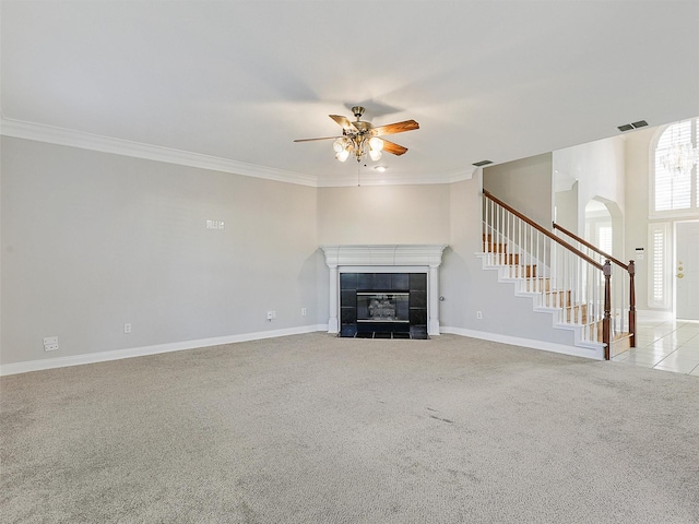 unfurnished living room with crown molding, a fireplace, ceiling fan, and light colored carpet