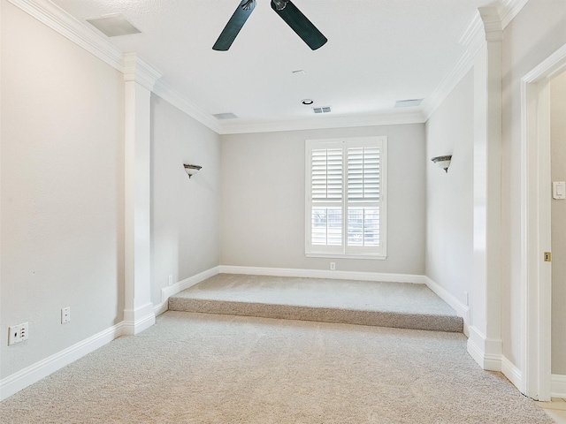 empty room featuring ceiling fan, carpet floors, and crown molding