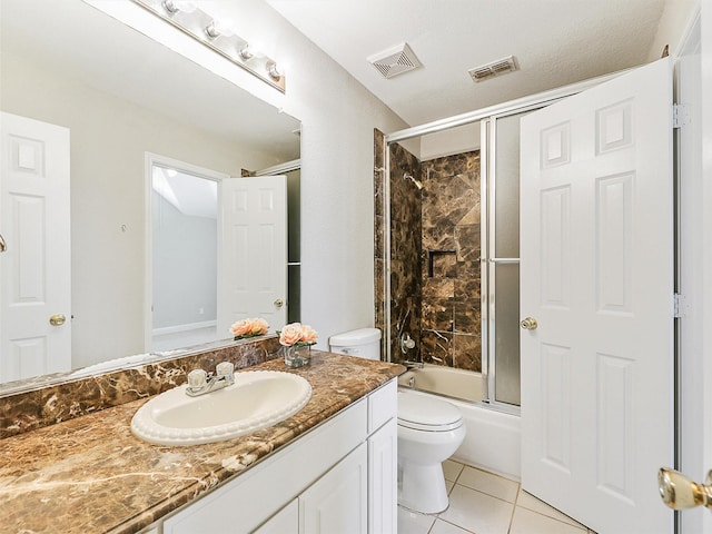 full bathroom featuring shower / bath combination with glass door, tile patterned flooring, vanity, and toilet