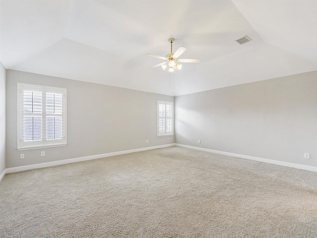 carpeted empty room featuring a tray ceiling and ceiling fan