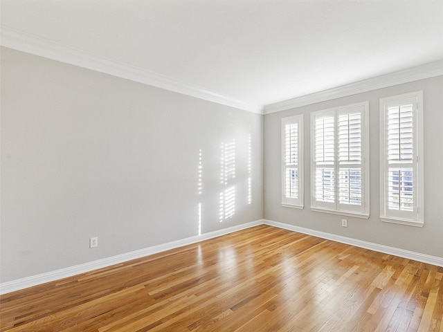 empty room featuring crown molding and light hardwood / wood-style flooring