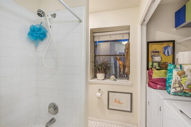 bathroom with tiled shower / bath combo and washing machine and clothes dryer