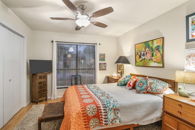 bedroom with light wood-type flooring, a closet, and ceiling fan