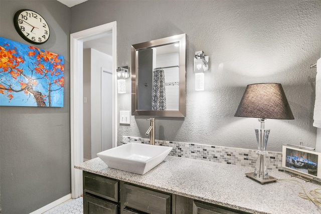 bathroom featuring decorative backsplash, curtained shower, and vanity