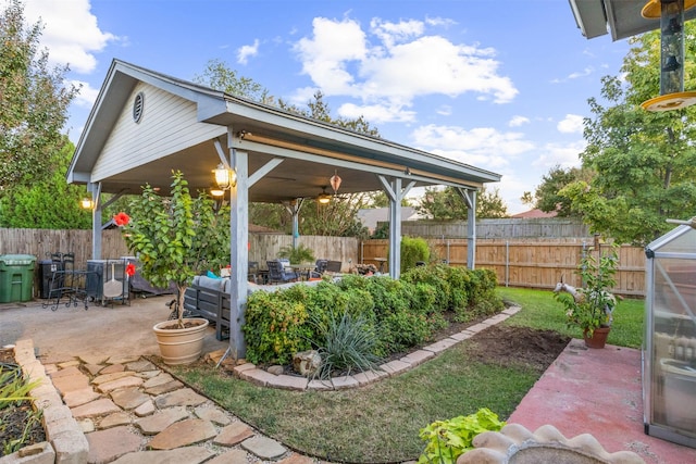 view of yard featuring outdoor lounge area, ceiling fan, and a patio