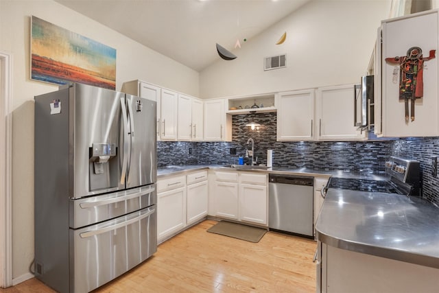 kitchen featuring white cabinets, sink, appliances with stainless steel finishes, tasteful backsplash, and stainless steel counters