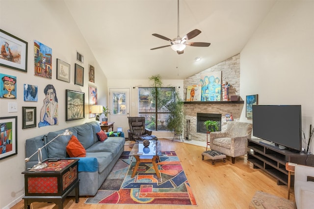 living room with a stone fireplace, ceiling fan, hardwood / wood-style floors, and lofted ceiling