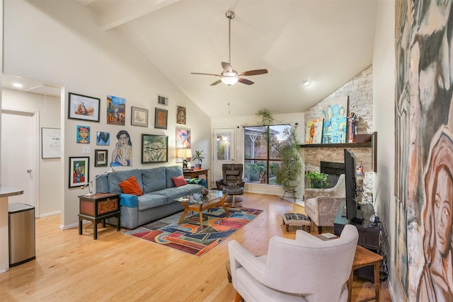 living room with ceiling fan, beam ceiling, high vaulted ceiling, a fireplace, and light hardwood / wood-style floors