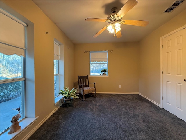 unfurnished room featuring ceiling fan and dark colored carpet