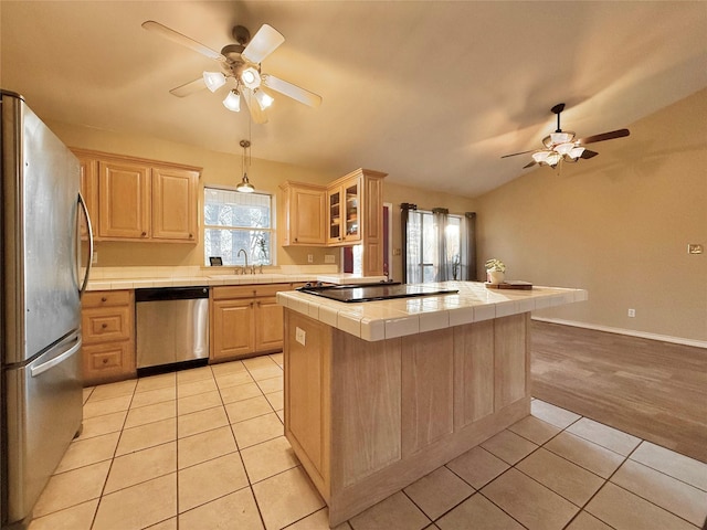 kitchen with ceiling fan, tile countertops, light brown cabinetry, light tile patterned flooring, and appliances with stainless steel finishes