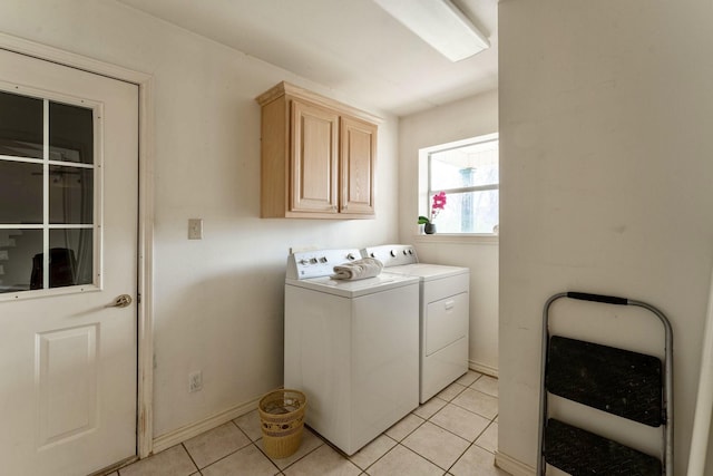 laundry room with cabinets, light tile patterned floors, and washing machine and dryer