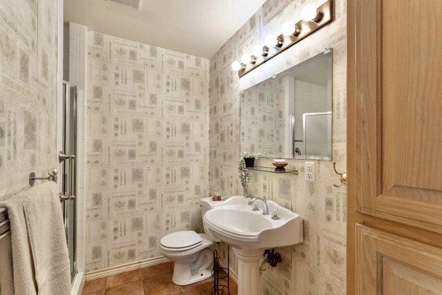 bathroom featuring a sink, visible vents, and wallpapered walls