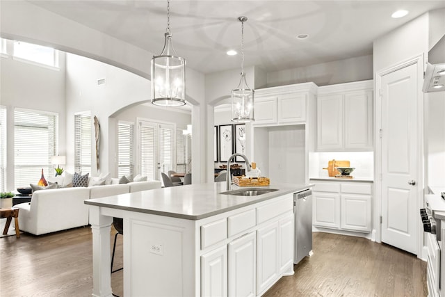 kitchen with white cabinetry, sink, an island with sink, and hanging light fixtures