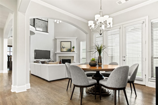 dining room with hardwood / wood-style flooring, crown molding, and a chandelier