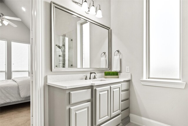 bathroom featuring ceiling fan, vanity, and lofted ceiling