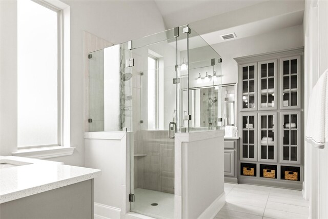 bathroom featuring tile patterned flooring, vanity, and an enclosed shower