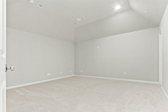 carpeted empty room with vaulted ceiling