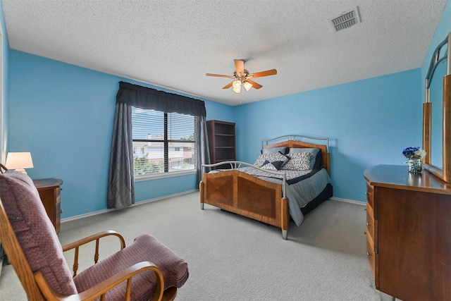 bedroom with light carpet, ceiling fan, and a textured ceiling