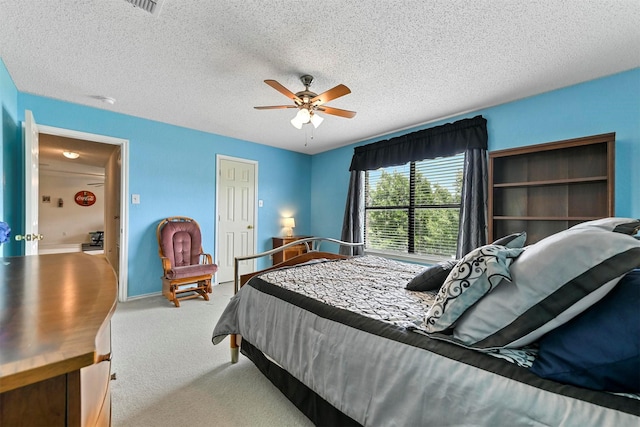 bedroom with a textured ceiling, ceiling fan, and carpet flooring