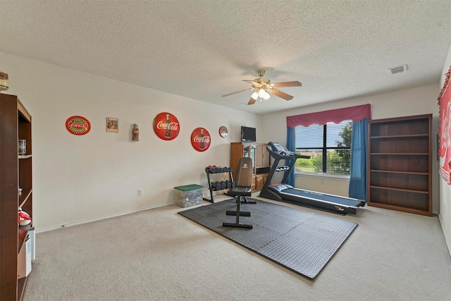 exercise room with carpet flooring, a textured ceiling, and ceiling fan