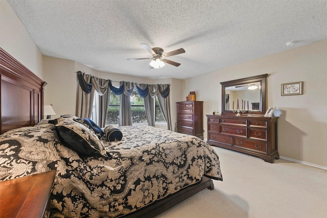 bedroom with ceiling fan, light carpet, and a textured ceiling