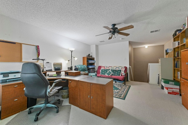 carpeted home office featuring ceiling fan and a textured ceiling