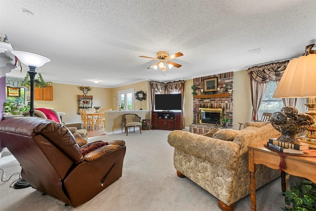 living room featuring a brick fireplace, carpet floors, a textured ceiling, and ceiling fan