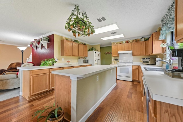 kitchen featuring white appliances, light hardwood / wood-style floors, sink, and a kitchen island